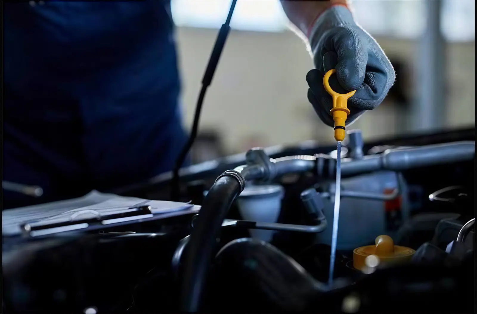 Shows a hand holding a handheld automotive diagnostic scan tool with a bright color interface screen in front of a car steering wheel.