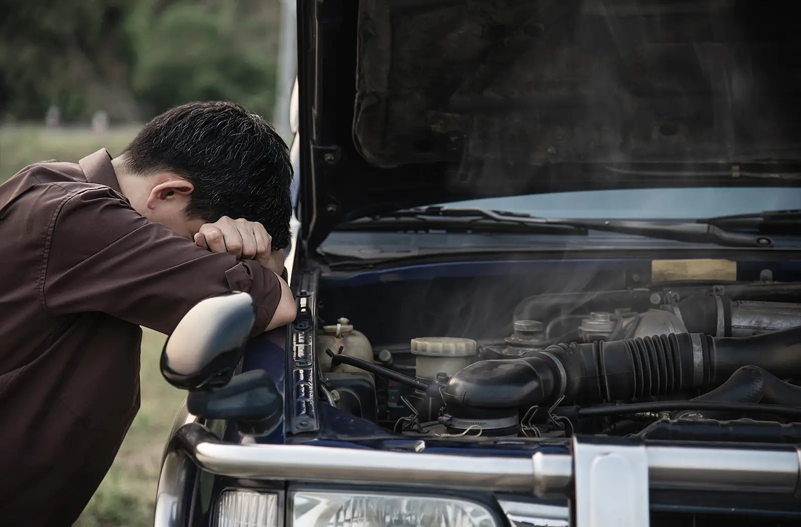 Shows a mechanical workspace containing essential engine tune-up parts, specifically focusing on a set of brand new spark plugs and ignition coils.