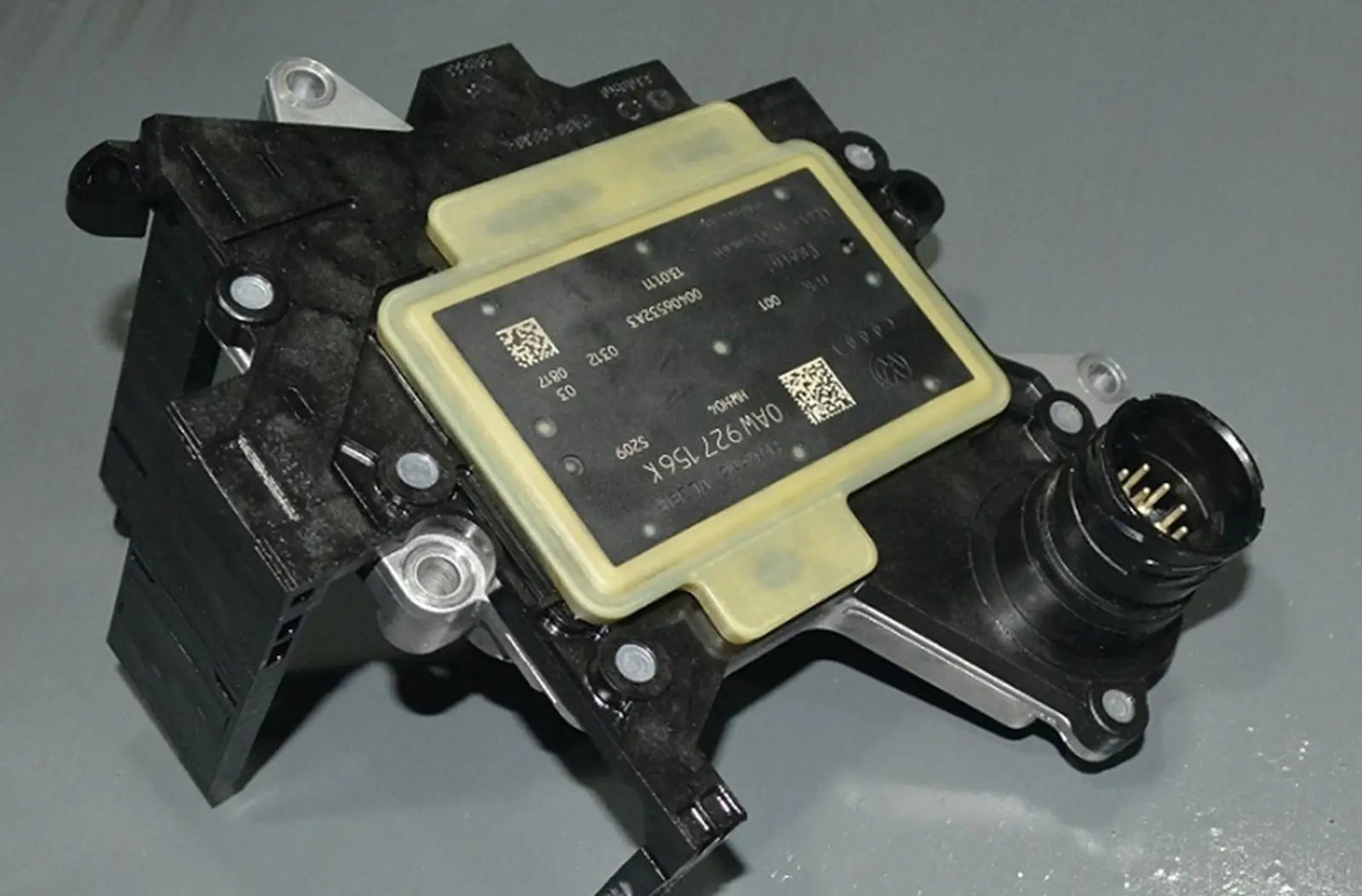 Shows a modern vehicle's digital dashboard display featuring an illuminated yellow "Check Engine" warning lamp alongside an explicit "Transmission Fault" service notification message.