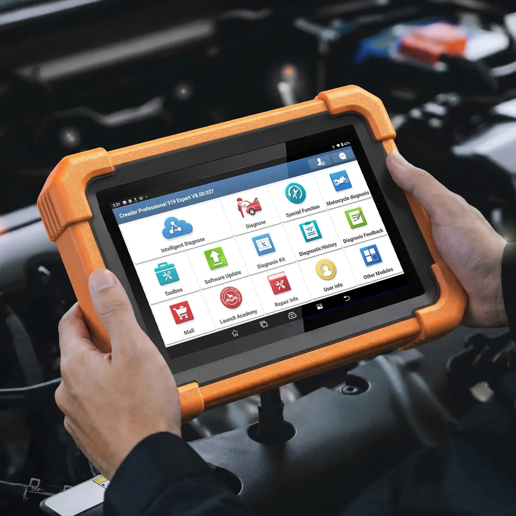a person's hands holding a LAUNCH Creader Professional 919 Expert diagnostic tablet over an open car engine bay. The device is enclosed in a rugged orange protective bumper and features a touchscreen displaying various automotive diagnostic menu icons.